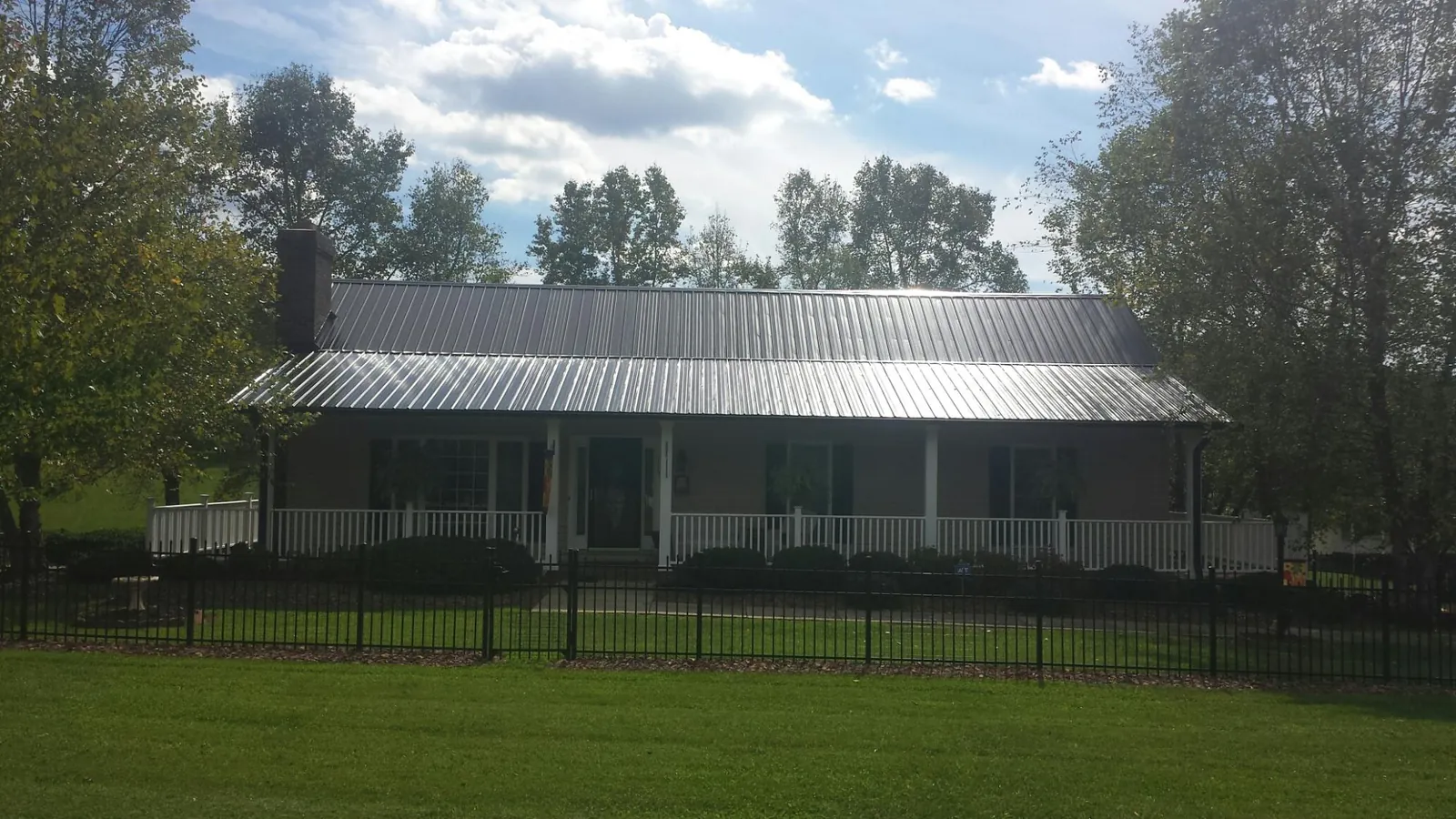 Gray metal roof on a brick ranch with a full width front porch — Gutter Guard Installation work by our crew in Santee